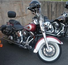 two motorcycles parked next to each other in a parking lot with concrete walls behind them