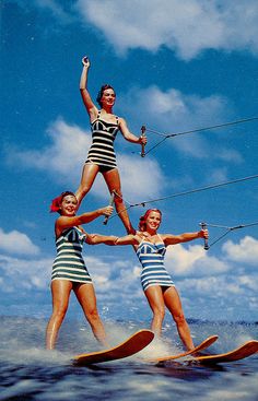 an old photo of three women on water skis