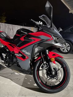 a red and black motorcycle parked in a parking lot