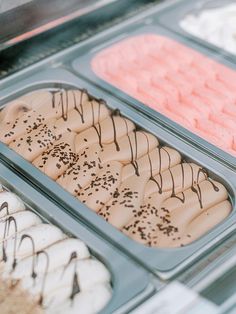 an assortment of desserts in trays on display