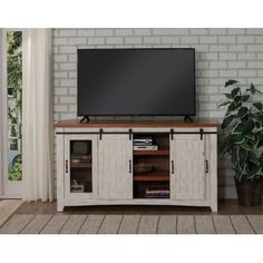 a flat screen tv sitting on top of a wooden cabinet