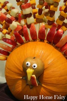 a turkey made out of candy sticks sitting on top of a pumpkin