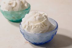 two bowls filled with whipped cream sitting on top of a white counter next to each other