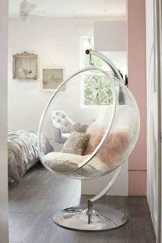 a bedroom with a hanging chair in the middle and a bed on the other side