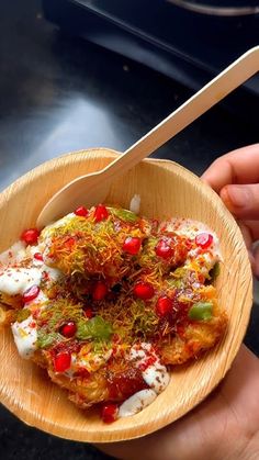 a person holding a wooden bowl filled with food