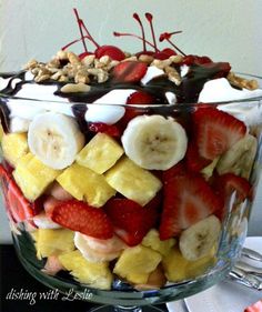 a fruit salad in a glass dish with nuts and chocolate