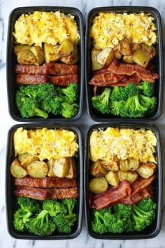 four black plastic containers filled with different types of food on top of a marble counter