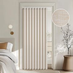 a bedroom with white and beige striped curtains on the door, bedding and pillows