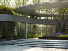 a circular building with plants and flowers in the foreground