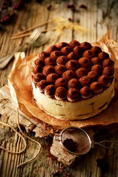 a cake sitting on top of a wooden table next to a pair of scissors and spoons