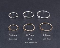 four different sizes of rings on a black surface with measurements for each ring and how to measure them