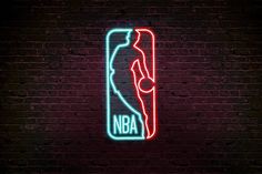 a neon sign that says nba on the side of a brick wall in front of a basketball court