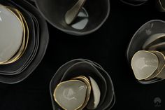 black and white dishes with gold rims are stacked together