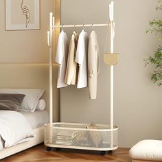 a bedroom with an ironing board and clothes hanging on the rails in front of a bed