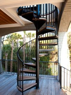 a spiral staircase in the middle of a wooden deck