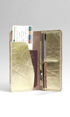 an open wallet with two cards and a passport in it, sitting on a white surface