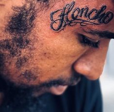 a man with a tattoo on his forehead has the word alcano written in black ink