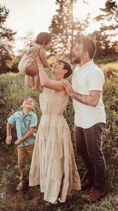 a man, woman and child are standing in the grass