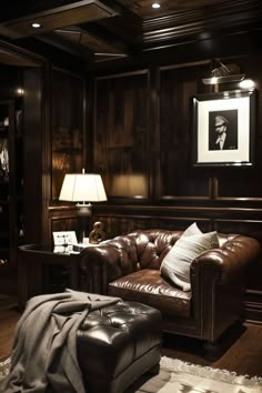 a brown leather couch sitting in a living room next to a lamp