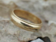 Here is a timeless and classic 14 k wedding band. The band measures approx. 6mm in thickness. The ring has personal engraving inside that is hard to read, but looks like '' Wed-Love M. I. Lovin You S.S.'' There is a beauty in the simplicity of this design. The size is 9 1/4-9.5. The inside of the ring is stamped 14k. The weight is 6 g. This item is pre-owned vintage and may show some wear commensurate with its age. We will point out any flaws, post pictures, and describe to the best of our abili Classic Gold Wedding Ring With Milgrain Detail, Classic Wide Band For Promise Ring, Classic Milgrain Jewelry For Marriage, Classic Wide Band Engraved Ring For Anniversary, Classic Wide Band Anniversary Bands, Anniversary Milgrain Round Band Ring, Classic Wide Band For Anniversary, Classic Yellow Gold Rings With Milgrain Detail, Classic 14k Gold Wedding Band