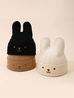 two knit hats with ears on top of each other, one black and one white