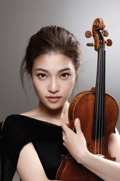 a woman holding a violin in her right hand