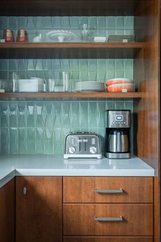 a toaster sitting on top of a counter next to a wooden shelf filled with dishes