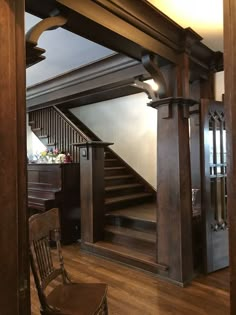 an empty room with stairs and wooden furniture