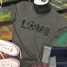 a t - shirt with the word love on it next to sneakers and a hat