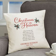 a christmas pillow sitting on top of a chair next to a cup and saucer