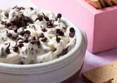 a bowl full of ice cream with chocolate chips on the side next to crackers