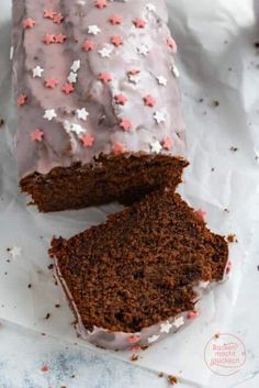 a chocolate cake with frosting and sprinkles on top is cut in half