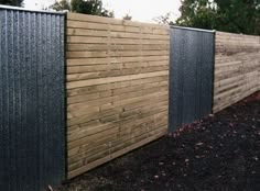 the fence is made of wood and has metal slats on it, along with black posts