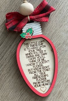 an ornament with a poem on it and a red ribbon hanging from the top