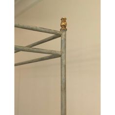 a metal bed frame with a golden bird on it's head and bottom rail