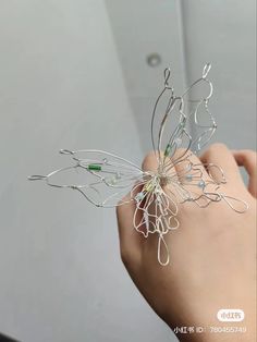 a hand holding a wire flower in it's palm