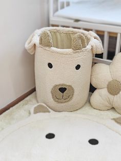 a teddy bear sitting next to a stuffed animal in a baby's crib