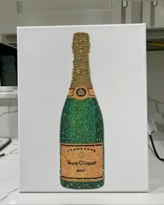 a painting of a bottle of champagne on a white canvas with green and gold sequins