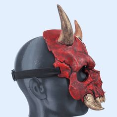 a red mask with horns on top of a head