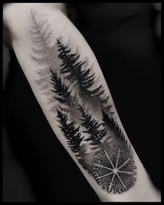 a black and white photo of a forest with compass tattoo on the arm, done by person