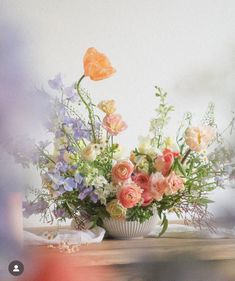 a vase filled with lots of flowers on top of a table