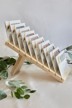 a wooden rack with cards on it next to eucalyptus leaves