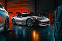 a silver sports car parked in front of a garage door