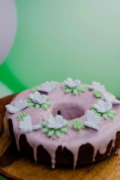 a frosted donut sitting on top of a wooden plate