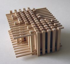 a model of a house made out of wooden slats on a white surface,