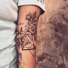 a woman's arm with flowers on it and an arrow in the middle is shown