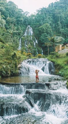 a woman standing on top of a waterfall