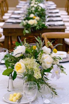 the table is set with white and yellow flowers