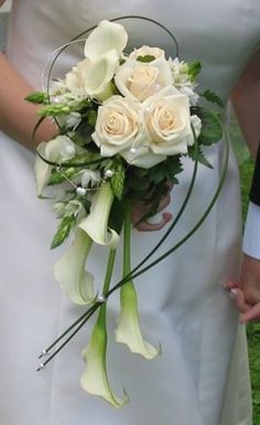 a bride holding a bouquet of white flowers