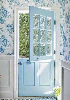 a blue front door in a white and blue wallpapered room